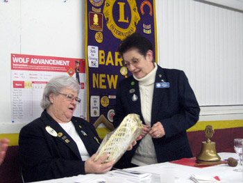 ion District Governor receives a gift basket from Barker Lion President Fran Costello.